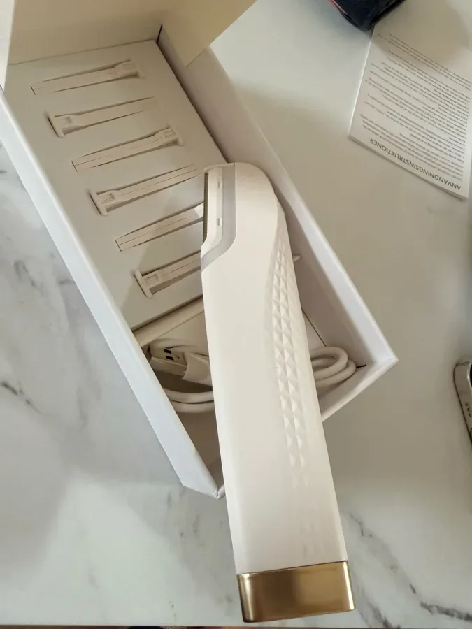 Peachly electric dermaplane device, white body with gold accents