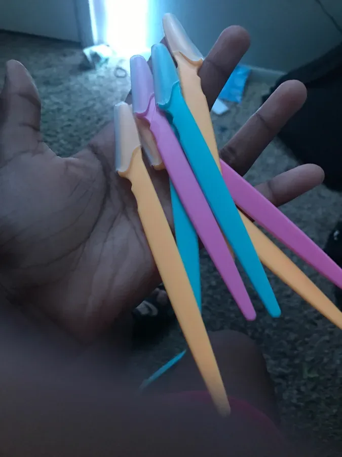 Hand holding a Peachly dermaplane razor